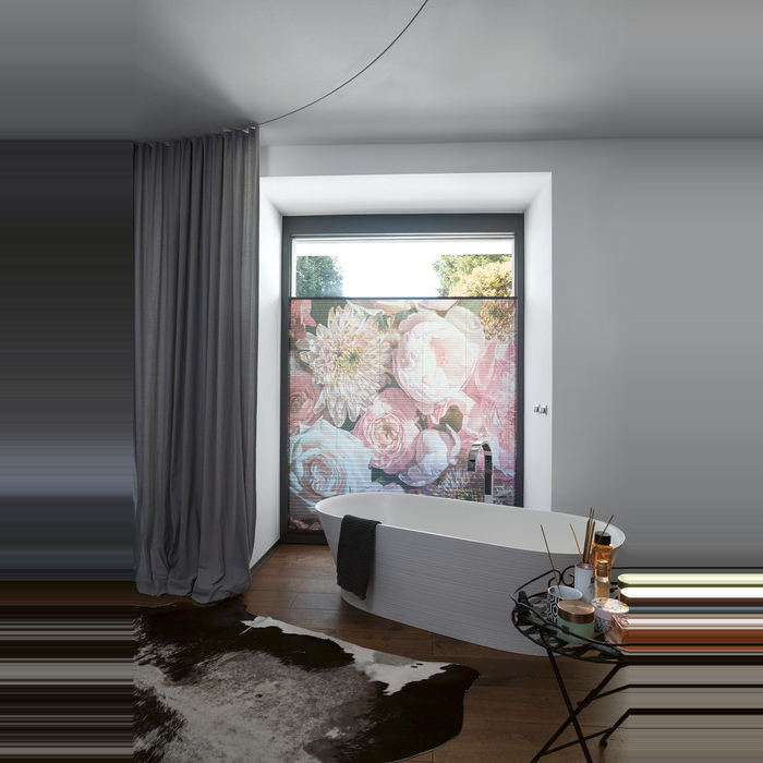 Ein lichtdurchlässiges MHZ Plissee in einem warmen Terrakotta- oder Rostton an einem Fenster. Die feine Stoffstruktur wird durch das durchscheinende Sonnenlicht hervorgehoben und wirft ein gemütliches, warmes Licht in den Raum. Im Hintergrund ist eine grüne Zimmerpflanze angedeutet.