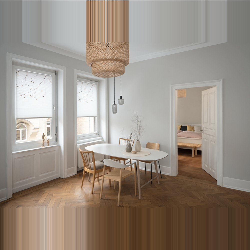 Ein hellbeiges MHZ Wabenplissee an einem Fenster in einem warm gestalteten Wohnraum. Das Plissee ist als Sichtschutz im unteren Fensterdrittel positioniert, während oben der Blick auf herbstliche Bäume frei bleibt. Im Vordergrund steht eine dekorative Vase mit Trockenblumen auf einem Holztisch, die das herbstliche Ambiente unterstreicht.