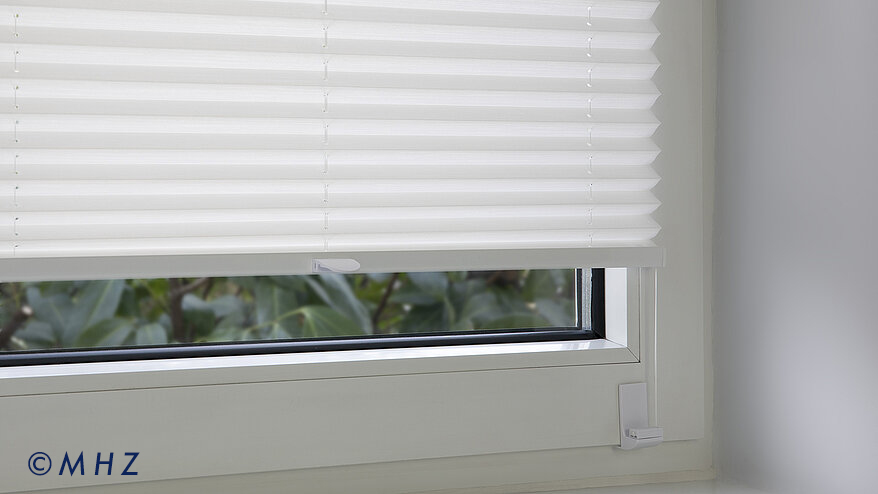 Montageart Winkelträger: Nahaufnahme der Befestigung eines Plissees am Fensterflügel mittels eines stabilen Winkels, der die Spannschnur vor dem Rahmen hält.