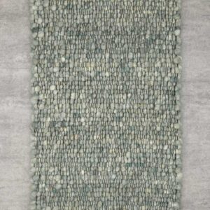 Detailaufnahme eines Haro Teppichs in Naturweiß aus reiner Schurwolle. Die Makroansicht zeigt die präzise Webtechnik ohne Knötchen und das plastische Muster der Hoch-Tief-Struktur, die für eine lebendige, helle Optik sorgt.