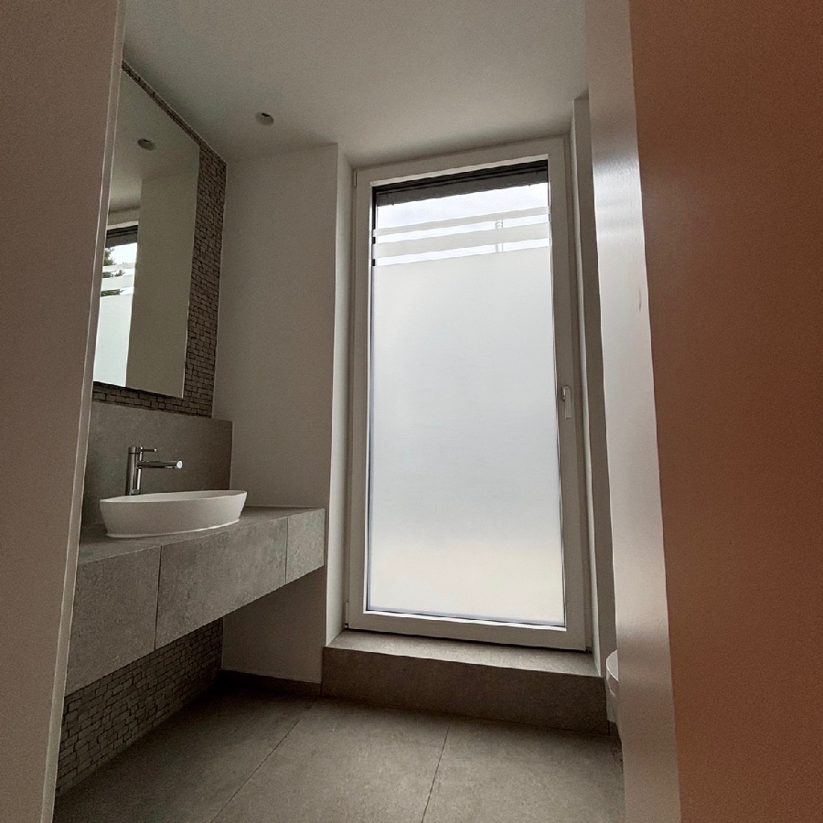 Professionelle Anbringung einer matten Milchglasfolie auf ein Fenster als Sichtschutz.